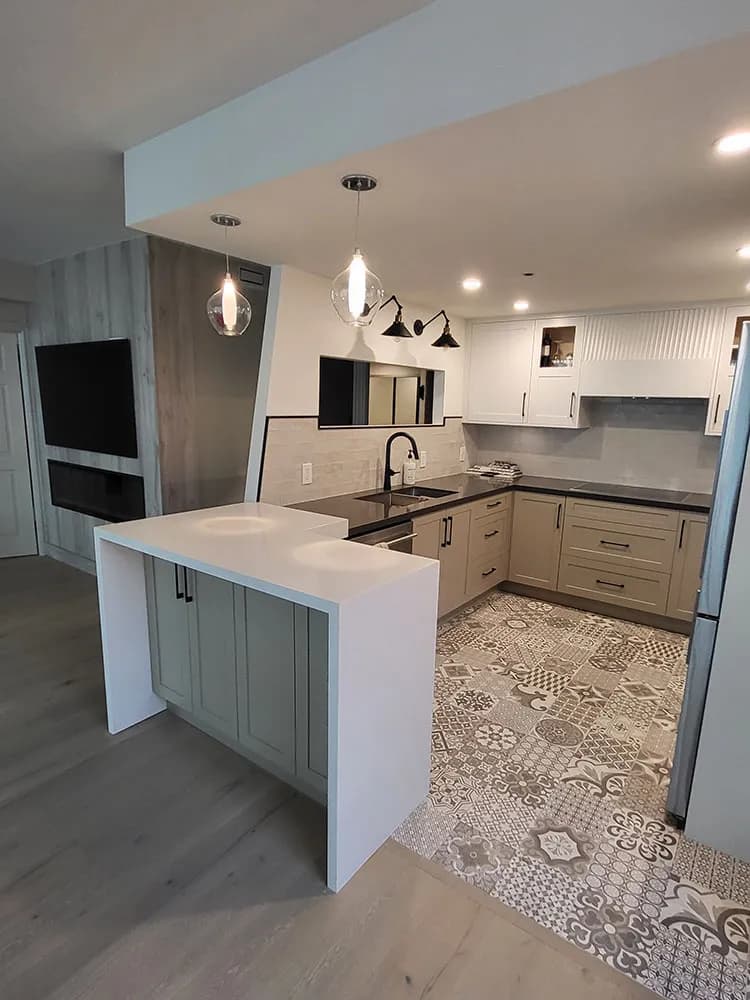 Renovated Toronto kitchen with sage green island, patterned tile floor, pendant lights, and white upper cabinets